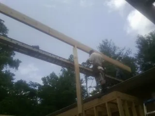 Carpenter setting a ridge beam over a new addition frame — Ice Dam Removal by Roofing Brothers in Elizabethport