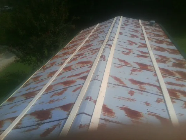 Rusted metal roof panels with new wood purlins before replacement — Storm Damage Roof Repair in Elizabethport by Roofing Brothers